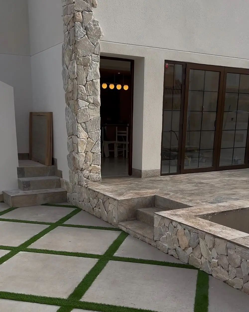 Finished patio with stone clad column and travertine paving